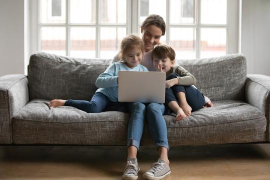 Mother watching videos on laptop with her children