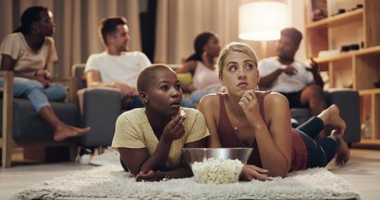 Friends eating pop-corn and watching film