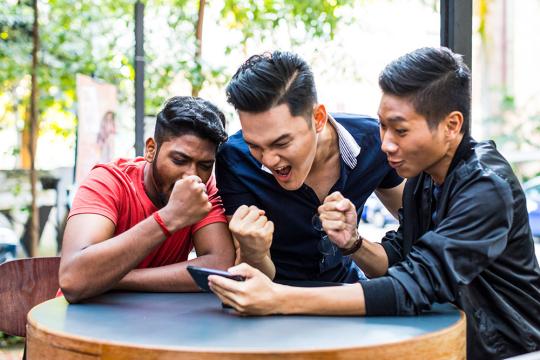 Friends watching match on mobile phone