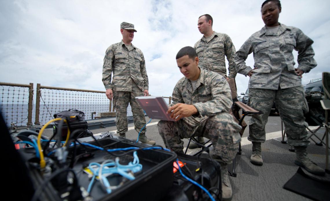 Soldiers setting up the laptop at a Naval Base.