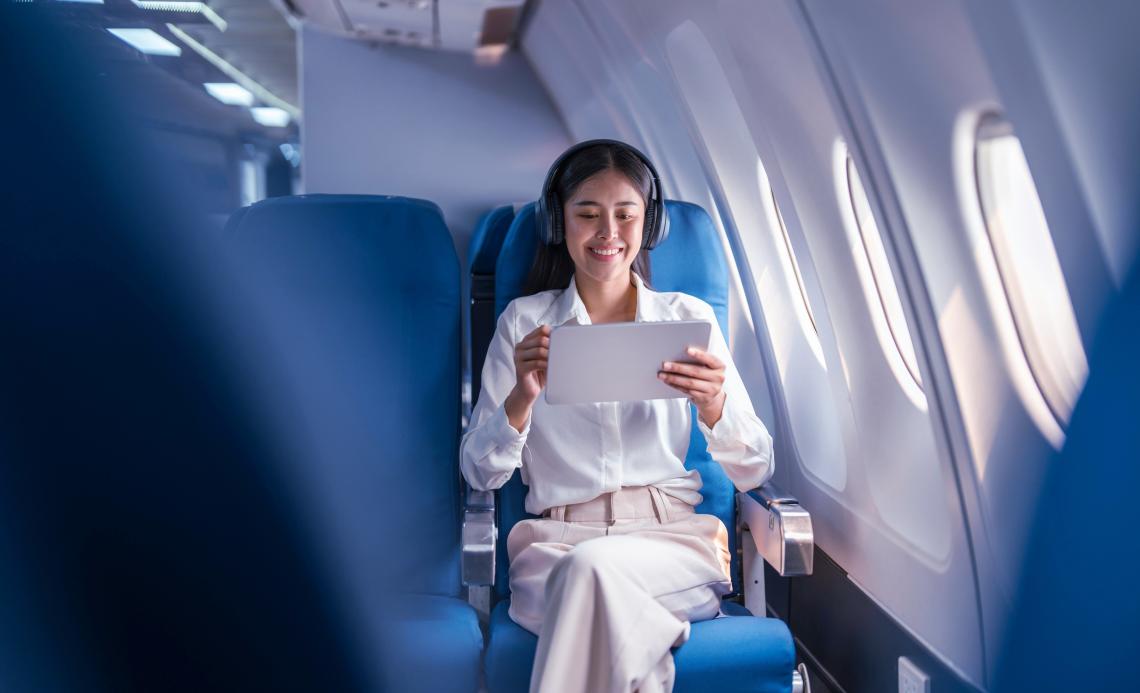 Image of a person using tablet on a flight.