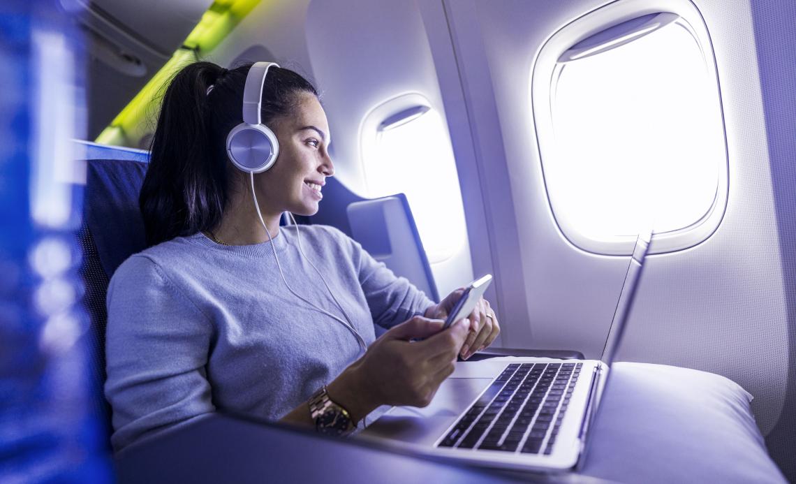 Image of a woman with Laptop and Smartphone in an airplane