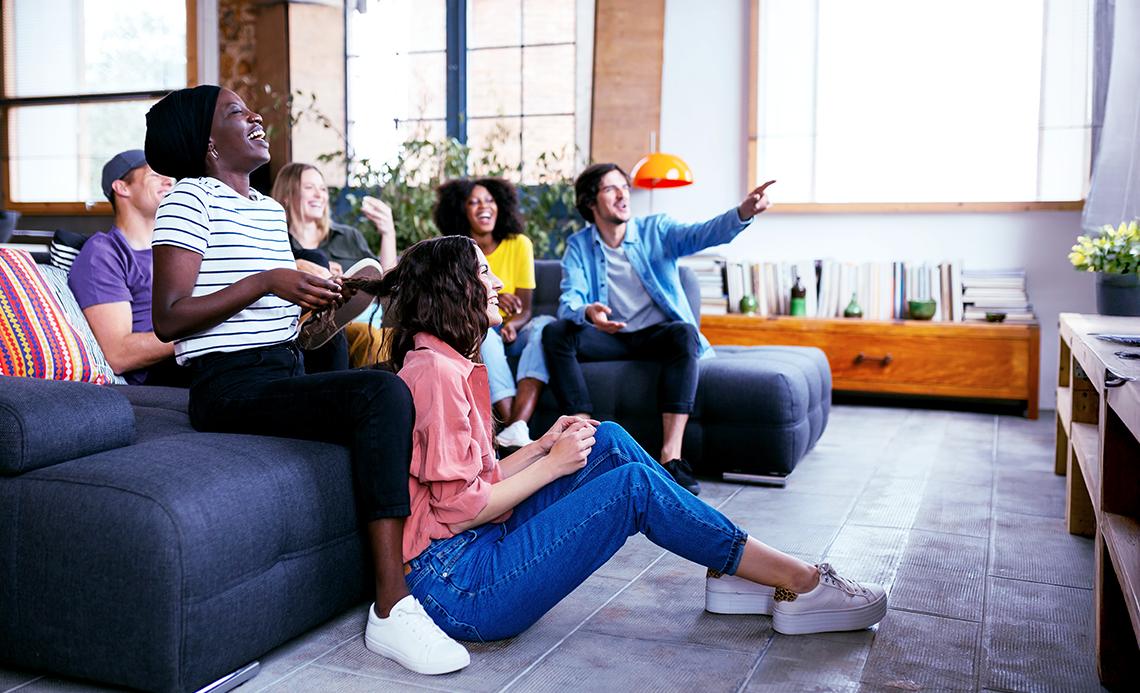 A group of friends sitting on a couch enjoying watching television