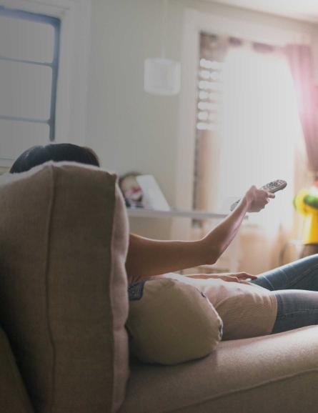 Woman on couch watching tv