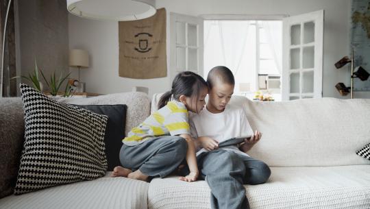 Children on couch with tablet