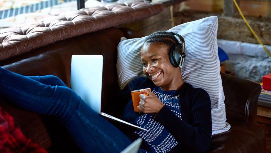 woman with headphones watching video on laptop