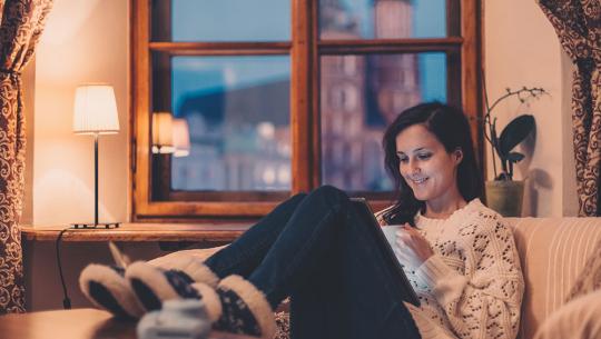 woman on sofa watching video on tablet