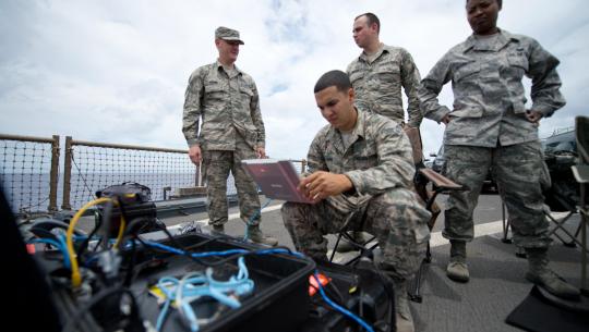 Soldiers setting up the laptop at a Naval Base.