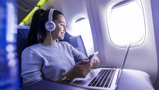 Image of a woman with Laptop and Smartphone in an airplane
