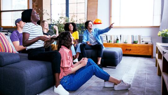 A group of friends sitting on a couch enjoying watching television