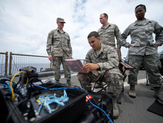 Soldiers setting up the laptop at a Naval Base.