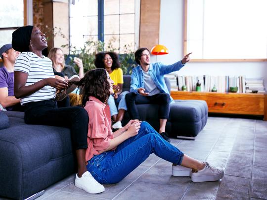 A group of friends sitting on a couch enjoying watching television