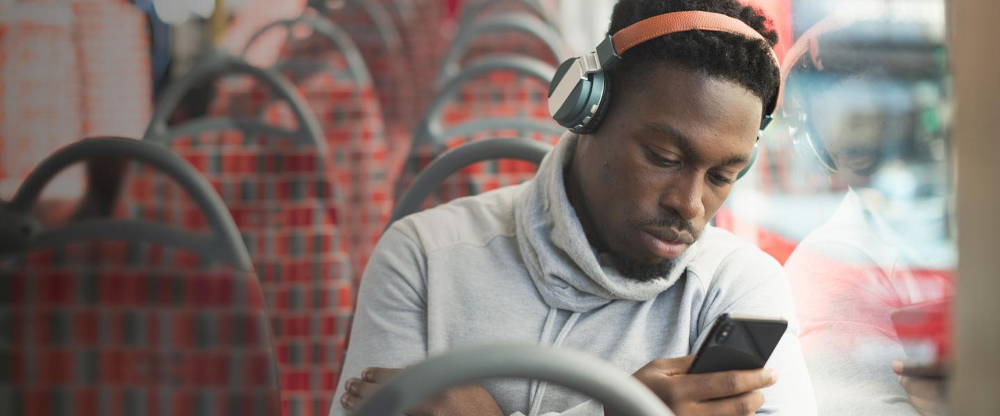 Man on bus with phone narrow banner