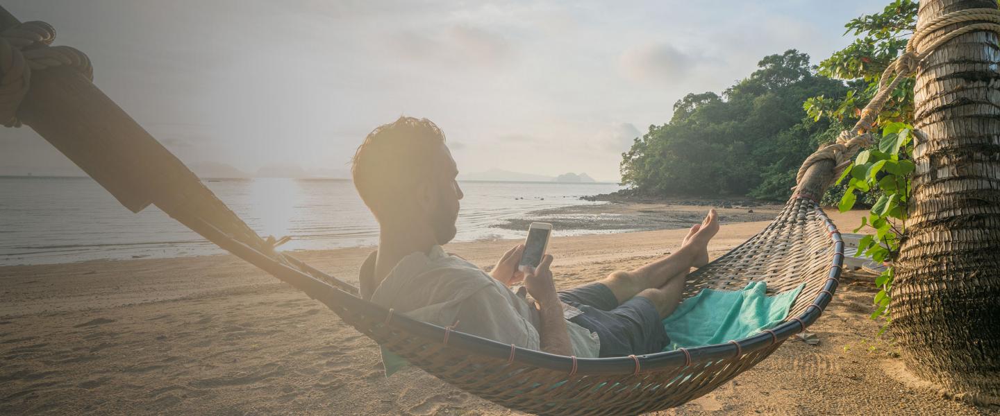 Man on beach with mobile banner image