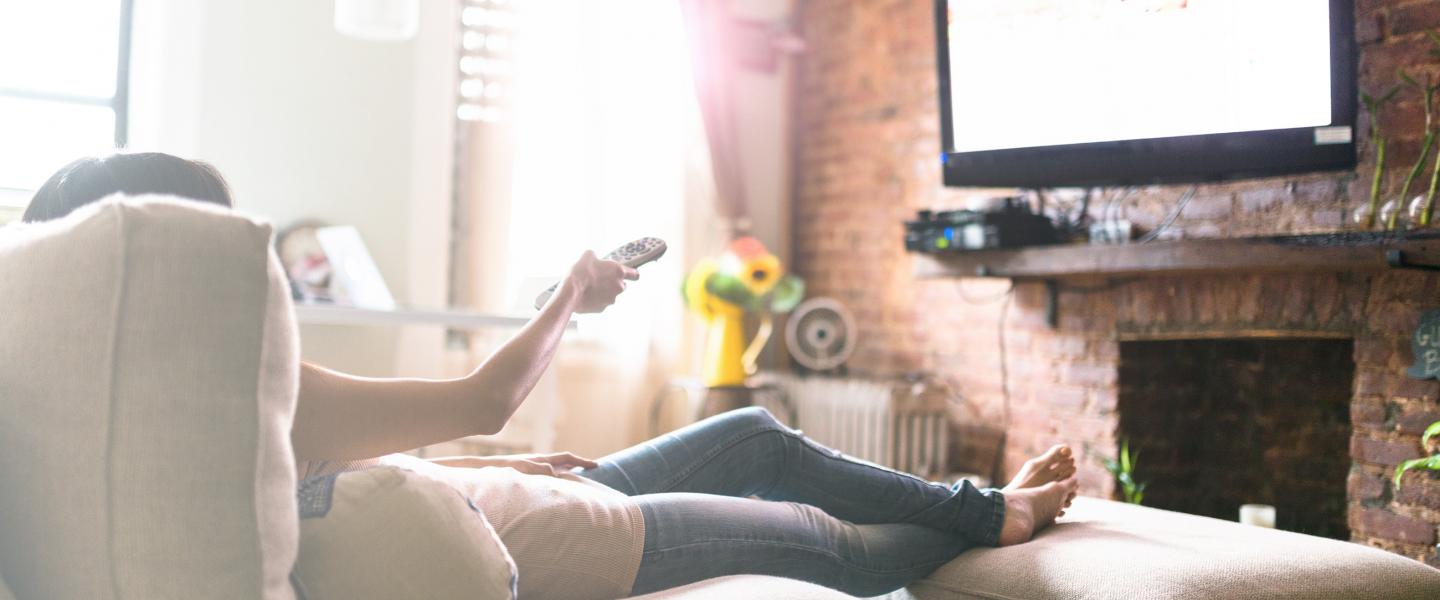 Woman on couch watching tv