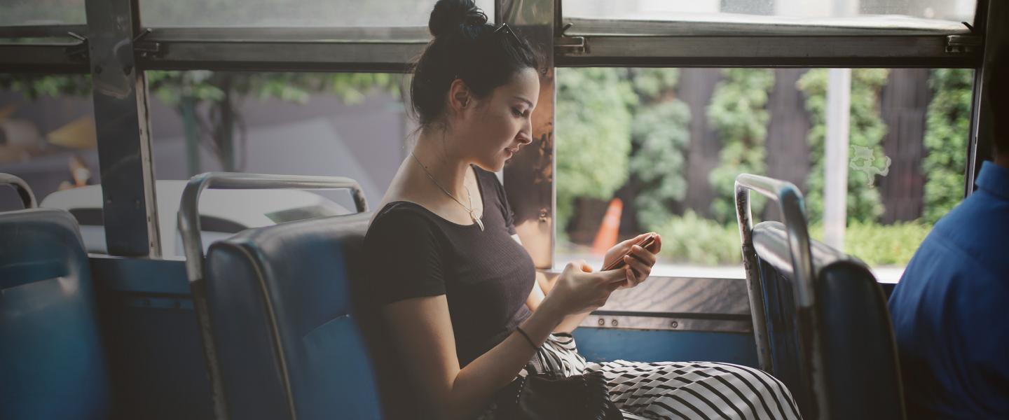 Woman with mobile on bus banner