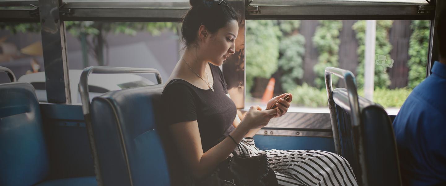 Woman with mobile on bus banner