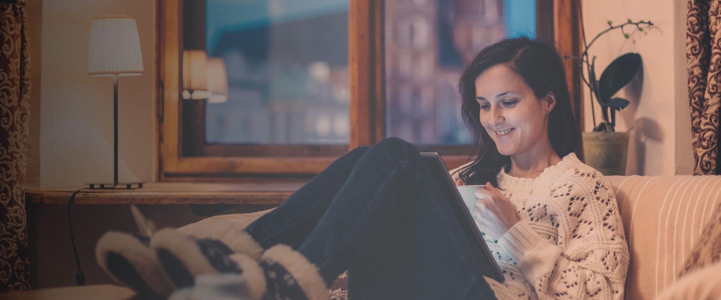 Woman on couch watching tablet