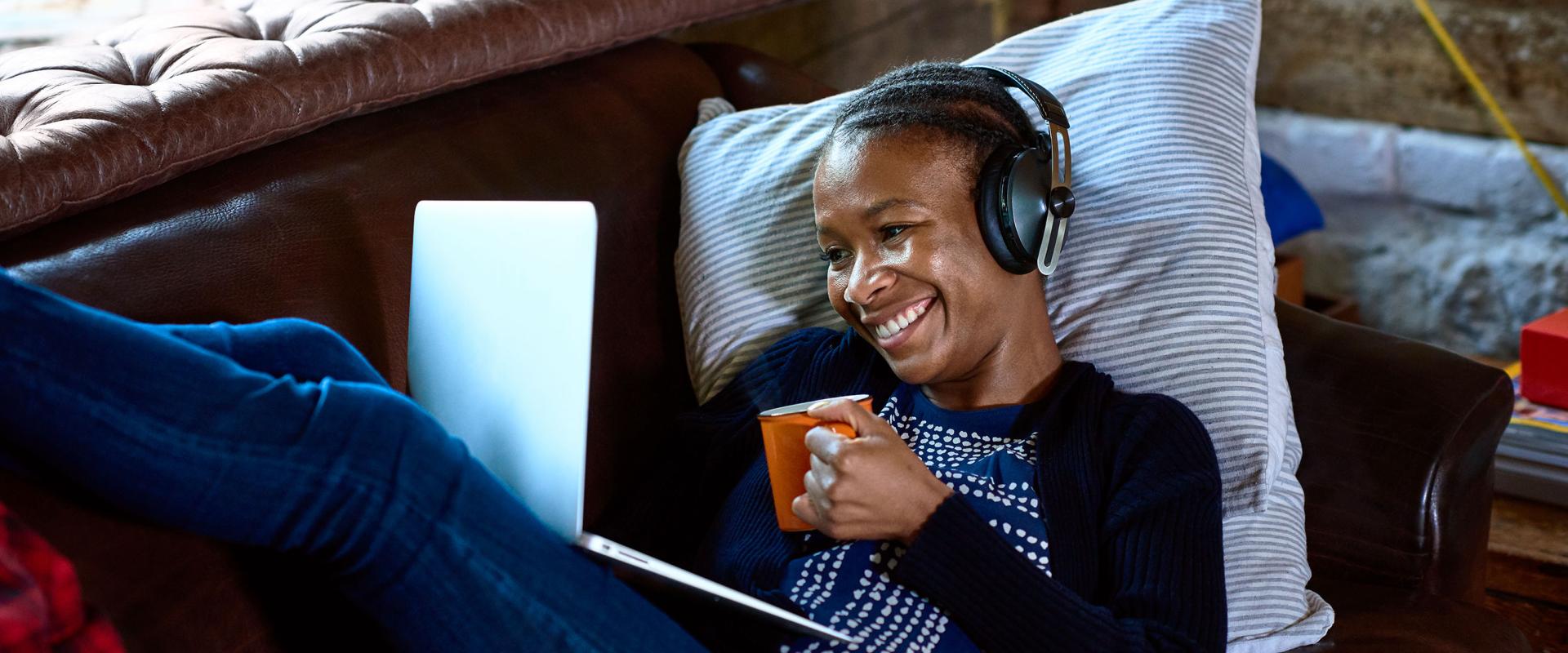 woman with headphones watching video on laptop