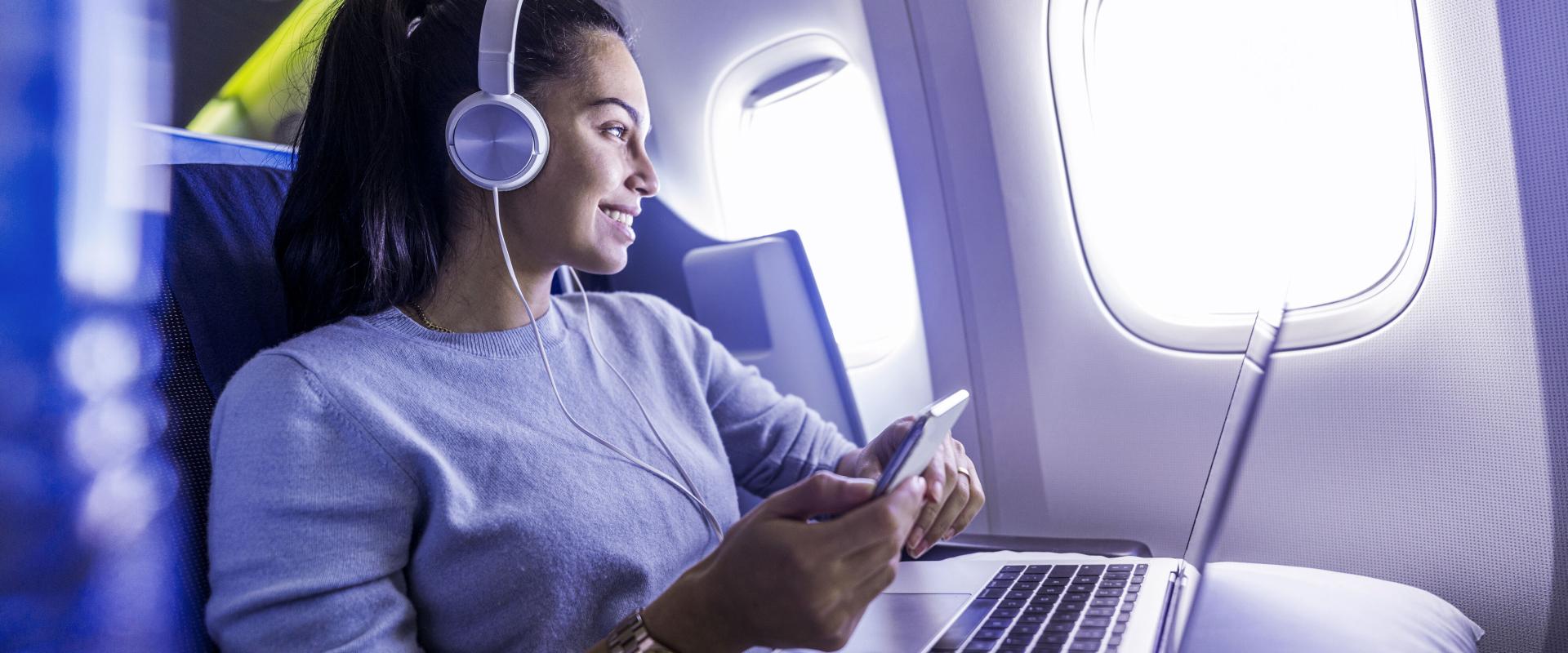 Image of a woman with Laptop and Smartphone in an airplane
