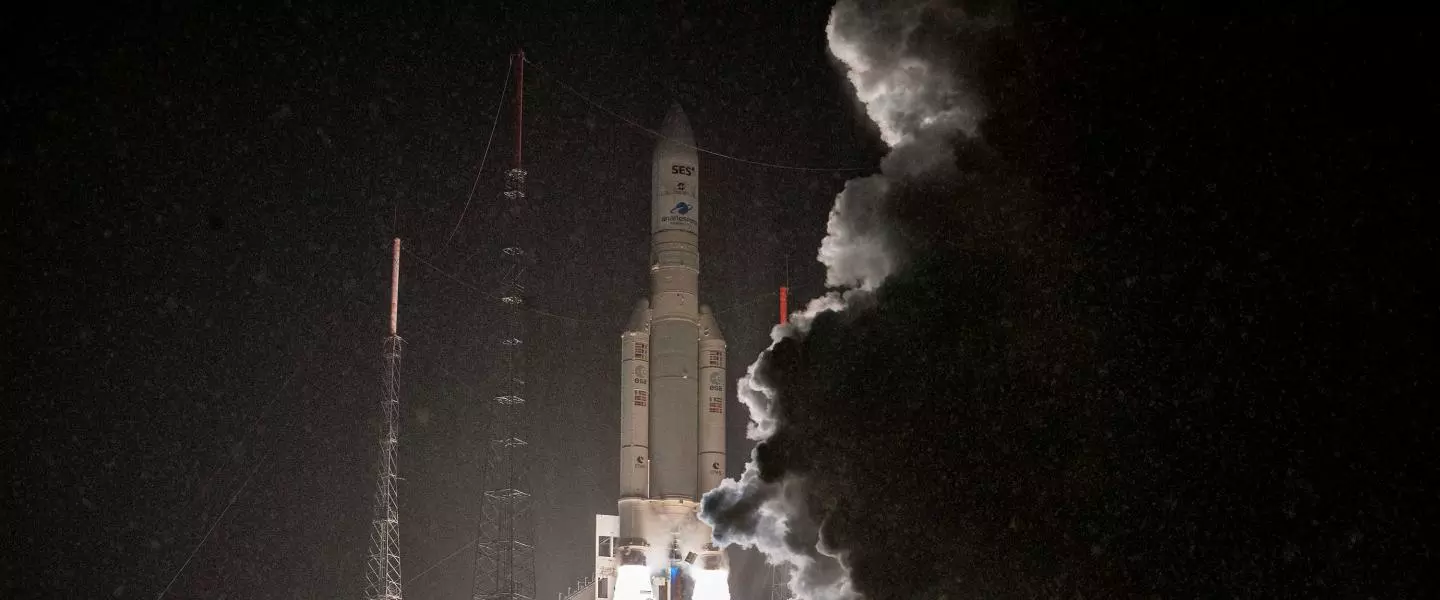 Rocket launching at night with bright exhaust and rising smoke