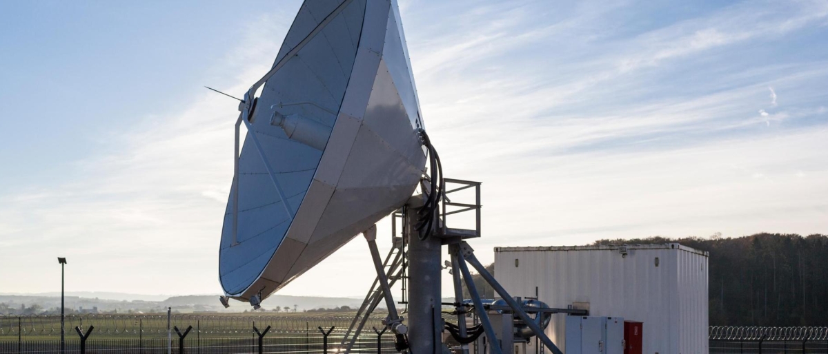 Image of a large satellite dish pointed toward the sky at a ground station.