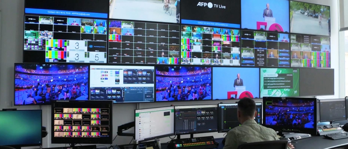 Image of a operator monitoring multiple broadcast feeds in a control room.