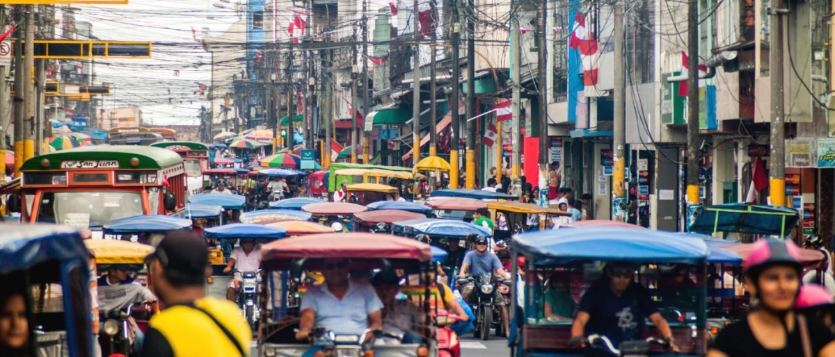 Image of a busy street packed with vehicles and people.