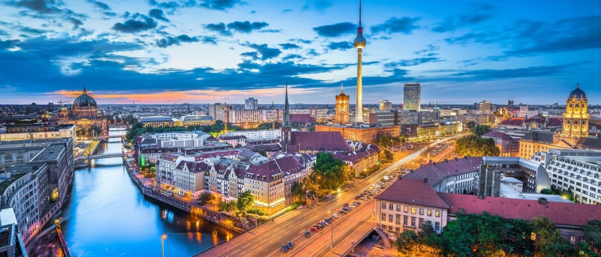 Cityscape at dusk featuring the TV Tower and illuminated streets.