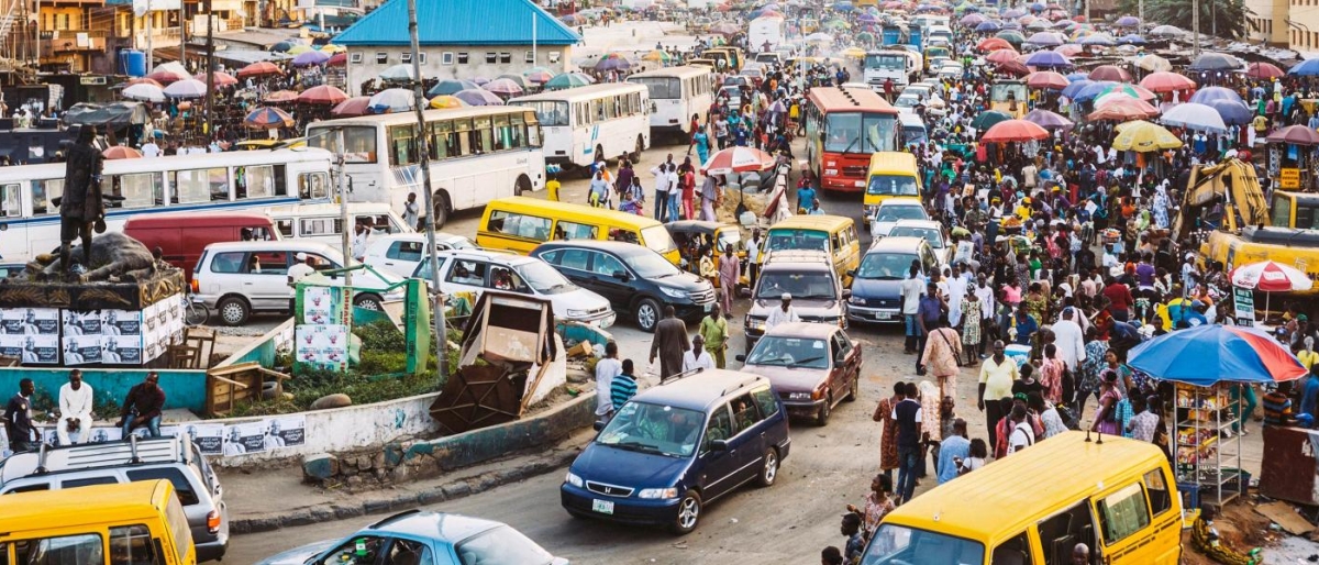 Image of a busy street packed with cars, buses and people.