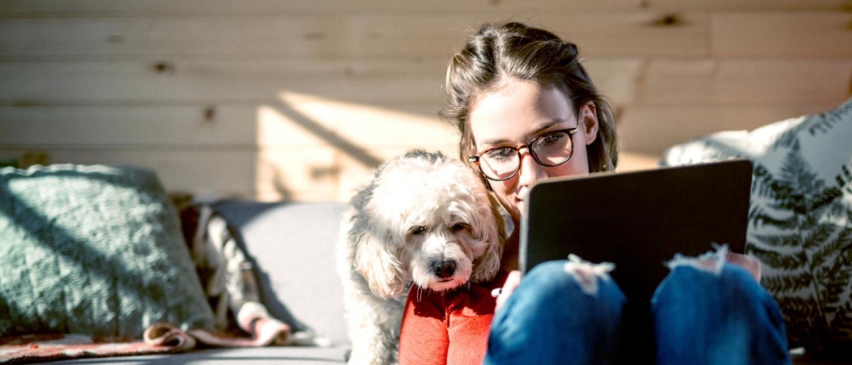 Image of a woman looking at a tablet screen with her pet