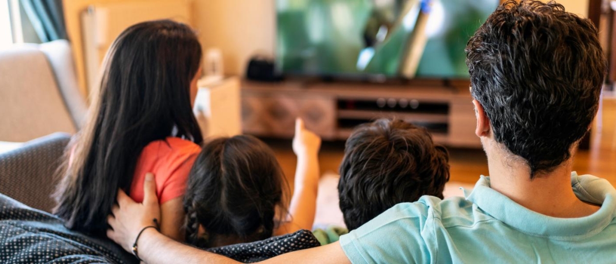 Image of a family sitting on the couch watching television.