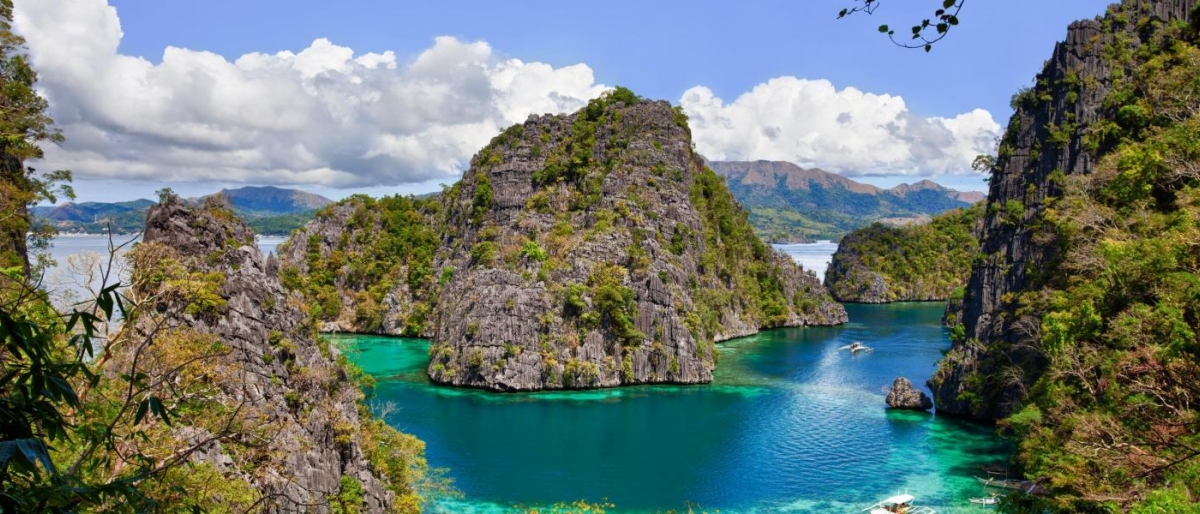 Image of turquoise lagoon surrounded by rocky green island.