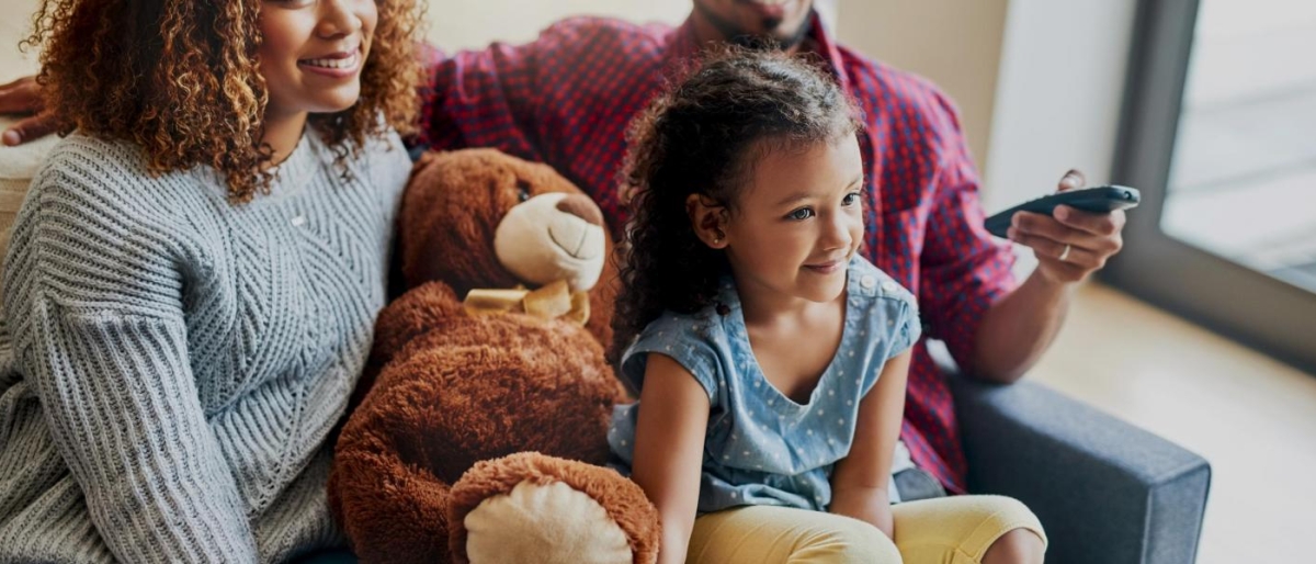 Image of a family sitting on a couch watching TV