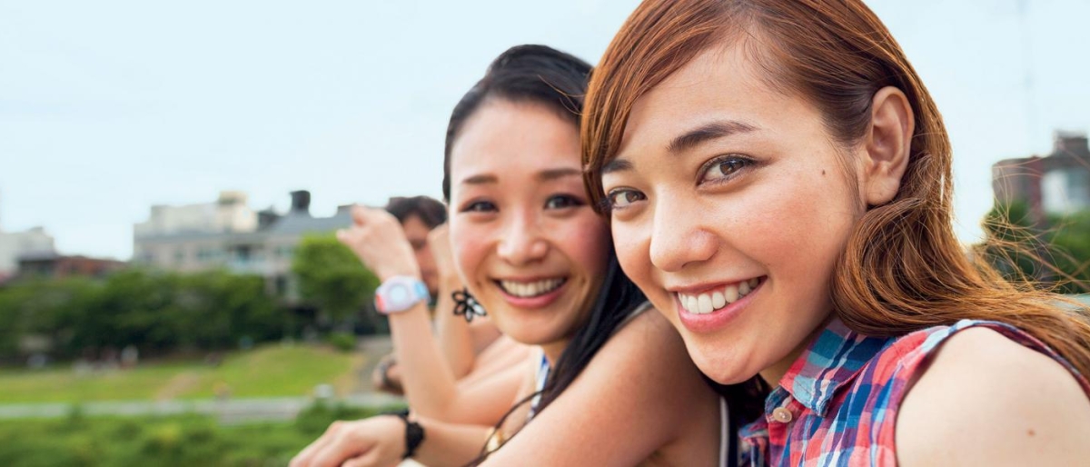 Image of two people clicking a selfie outdoors.