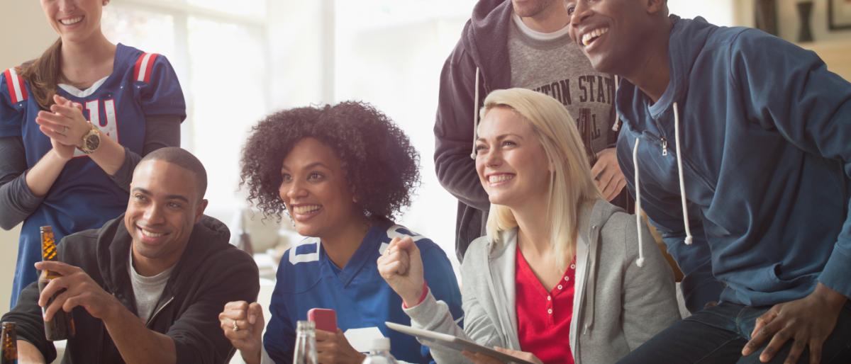 Image of a group of friends cheering while watching a game.