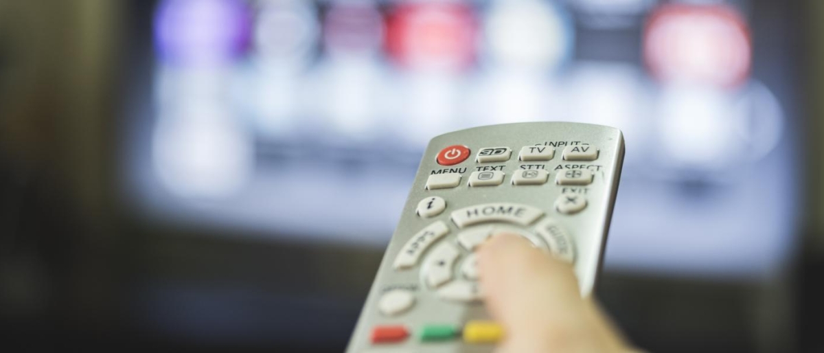 Close-up image of a remote and TV in the background.