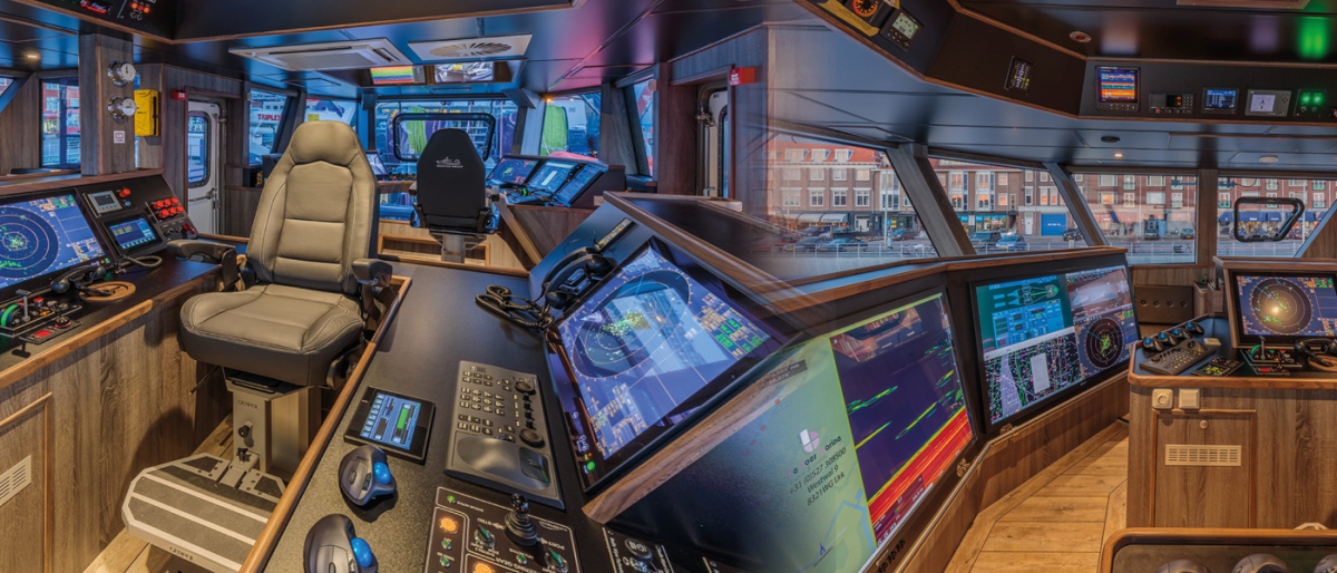 Image of ship bridge with navigation screens and controls.