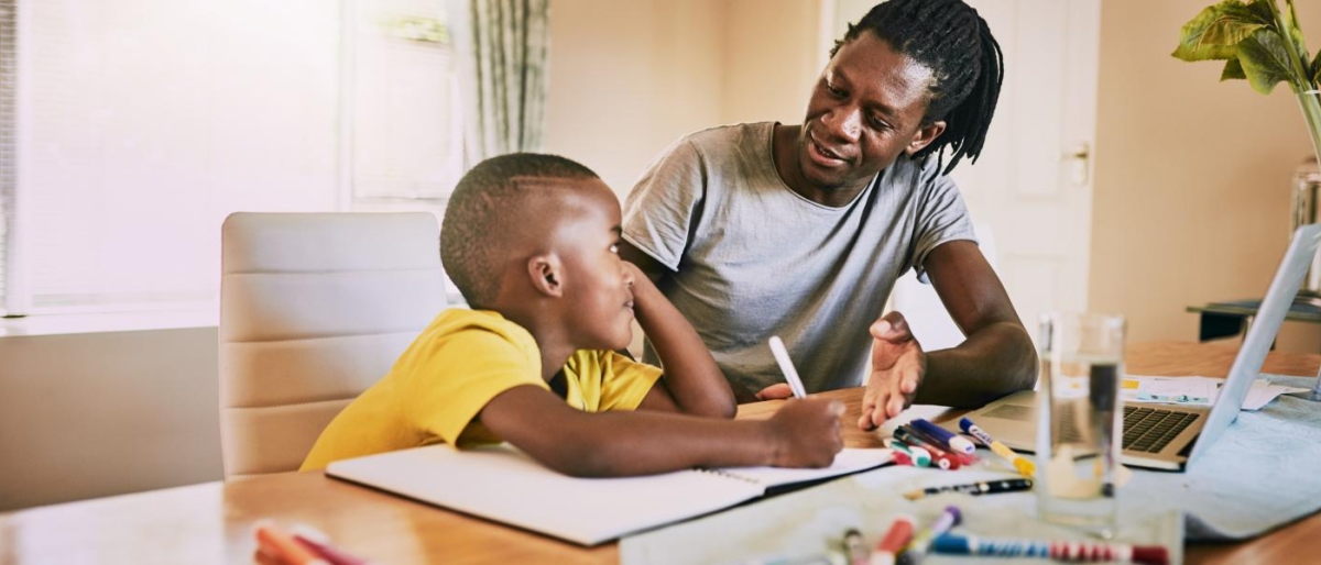 Image of an adult teaching a kid with a latptop.