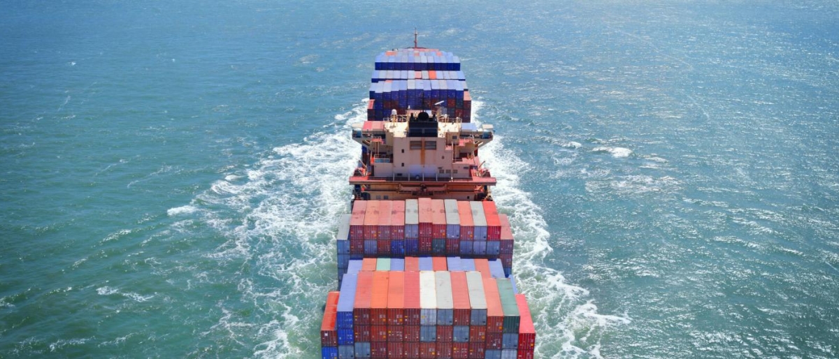 Image of a cargo ship carrying goods sailing in the sea.
