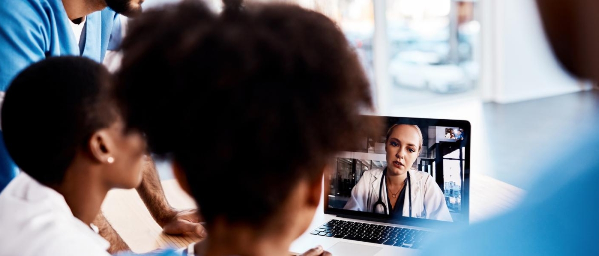 Image of medical professionals talking to a doctor via laptop.
