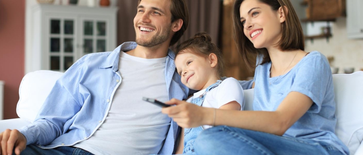 Image of a family sitting on the couch watching television.