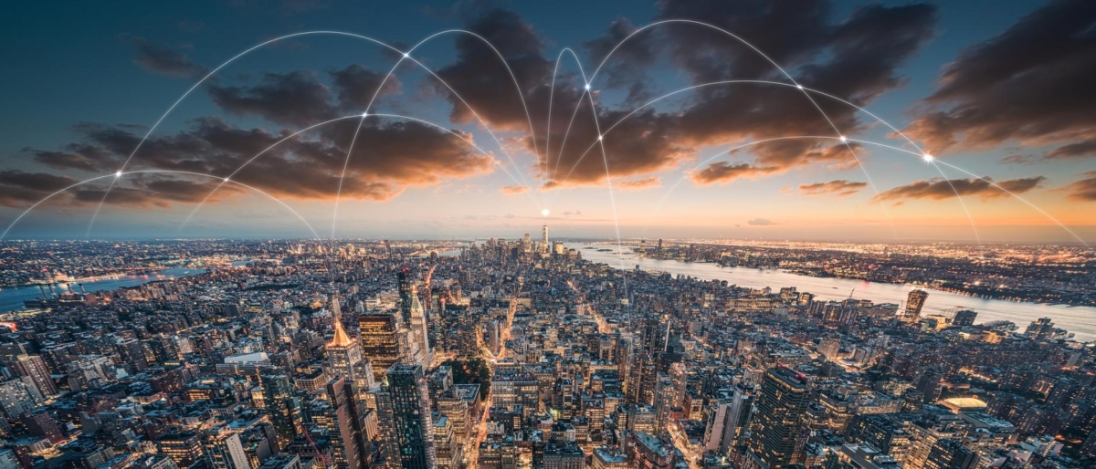 Image of city skyline with glowing network arcs across buildings.