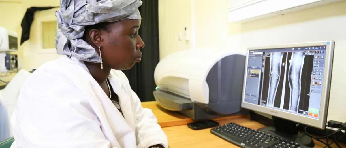 Image of medical professional reviewing leg X‑ray images on a computer.