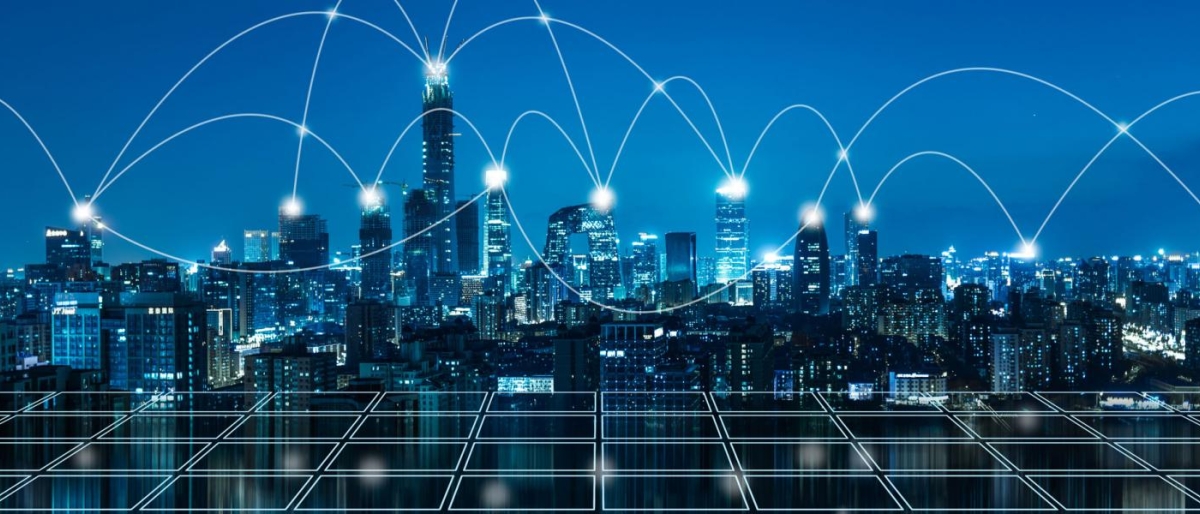 Image of city skyline at night with glowing network lines across the buildings.