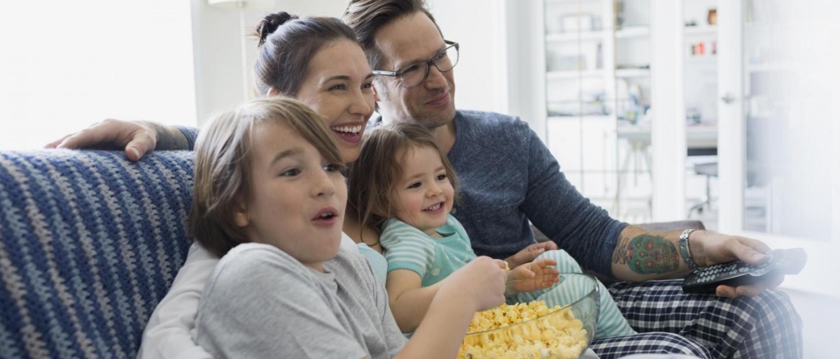 Image of a family sitting on the couch watching television.