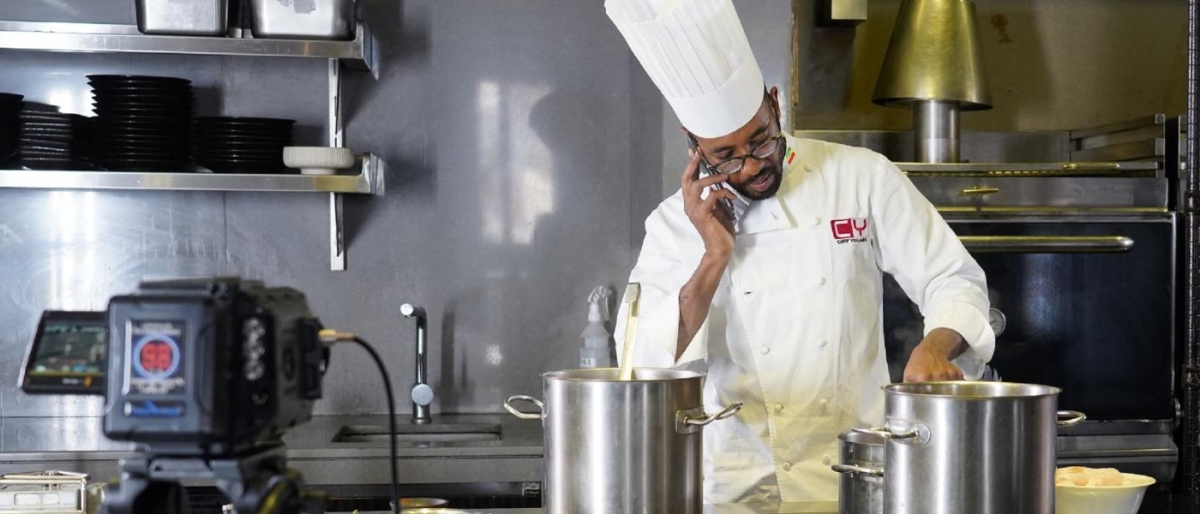Image of a chef working while talking on the phone