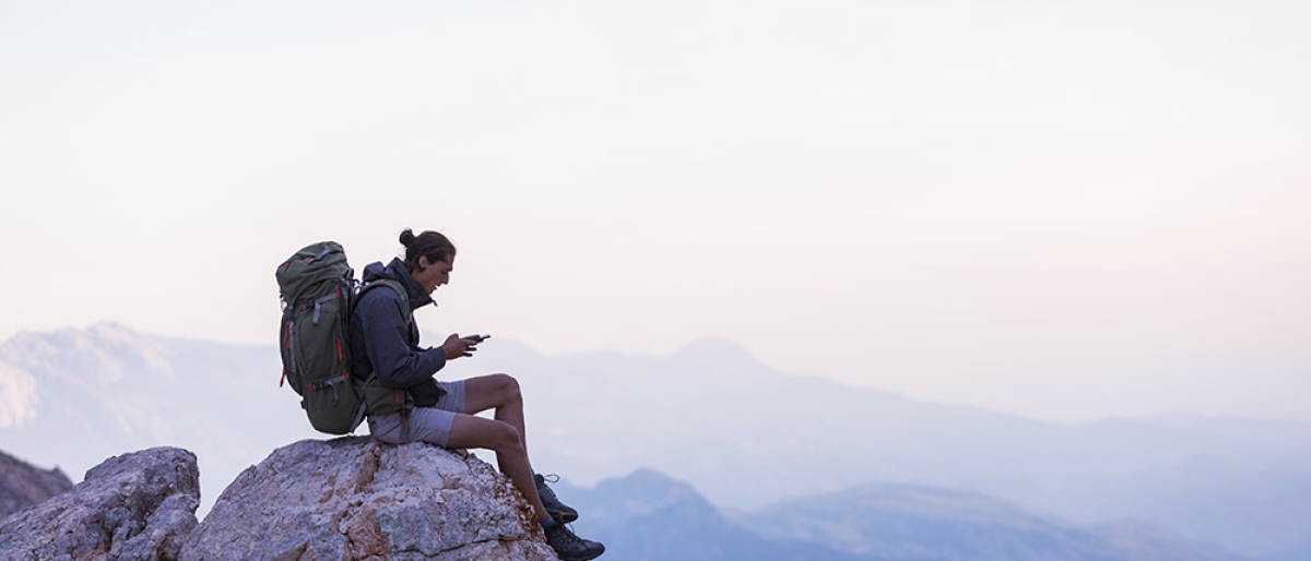 Man on mountain with mobile phone