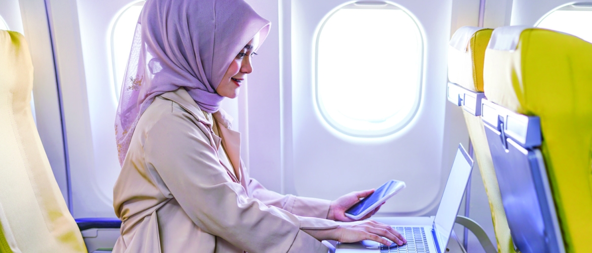 woman using laptop and cellphone on flight