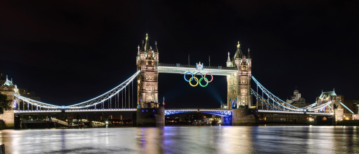 Image of Tower Bridge at night featuring glowing Olympic rings.